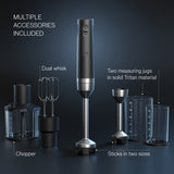 Wilfa Prostick immersion blender with accessories on a dark background, labeled 'Multiple accessories included': dual whisk, chopper, sticks in two sizes and two measuring jugs in solid Tritan material.